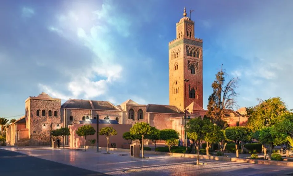 View of the Koutoubia Mosque in Marrakech with its tall historic minaret surrounded by palm trees