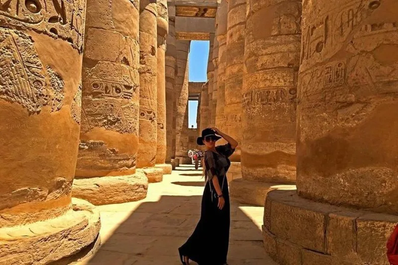 Visitors exploring the columns of Luxor Temple while enjoying the sunny weather