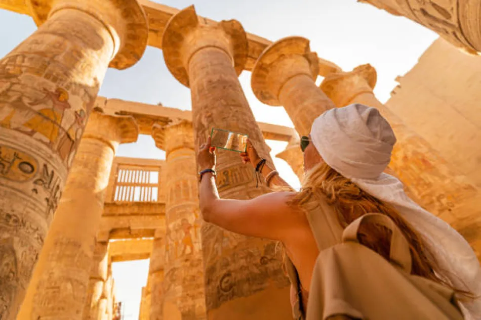 A tourist taking photos of ancient monuments and treasures in Luxor, Egypt
