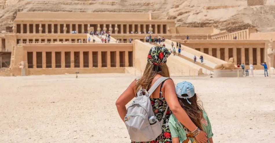 Tourists exploring the Temple of Hatshepsut in Luxor, Egypt, with its terraced architecture