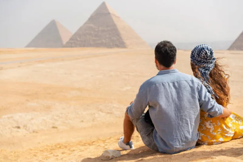 Two travelers admiring the Pyramids of Giza during a Cairo day trip